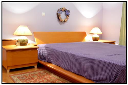 a bedroom with a bed and two night stands with lamps at Elegant Stone Mansion in Historic Mystras in Mystras