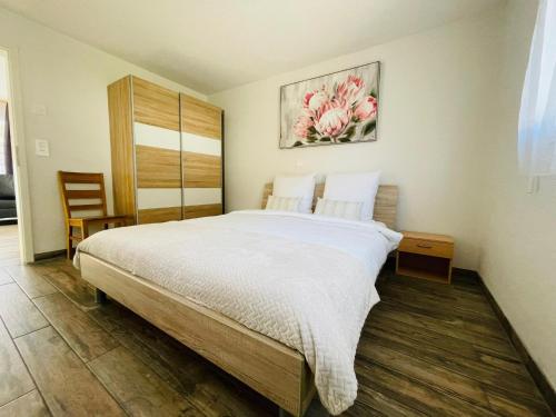 a bedroom with a large bed and a painting on the wall at Swiss Chalet Holidays Ringgenberg in Ringgenberg