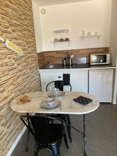 une cuisine avec une table avec des chaises et un micro-ondes dans l'établissement Studio Beach House à Sangatte bord de plage, à Sangatte
