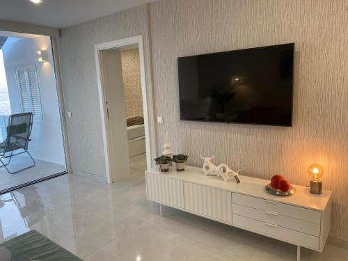 a living room with a tv on a wall at ocean experience / EXPERIENCE HOLIDAYS TENERIFE in Callao Salvaje