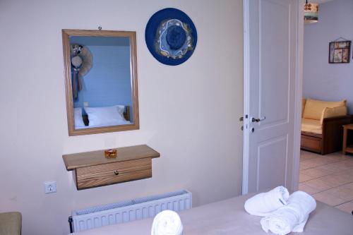 a room with a mirror and a bed with towels at Koukounaries Apartments Limni in Límni