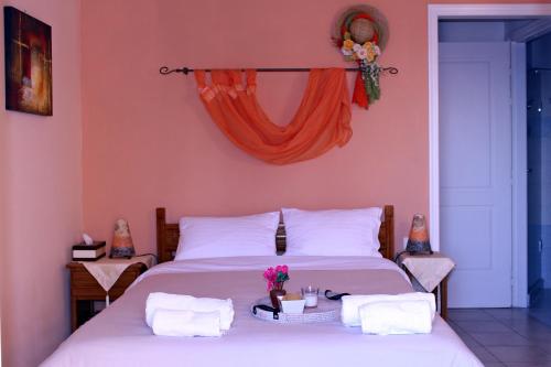 a bedroom with two beds with white sheets and flowers at Koukounaries Apartments Limni in Límni