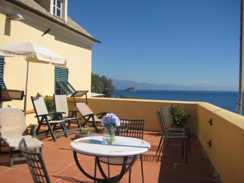 a patio with chairs and a table and an umbrella at Palazzo Vescovile Hotel in Noli