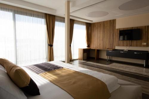sypialnia z dużym łóżkiem i telewizorem w obiekcie Carpe Diem Hotel w mieście Ayvalık