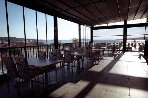 a restaurant with tables and chairs on a balcony at Carpe Diem Hotel in Ayvalık