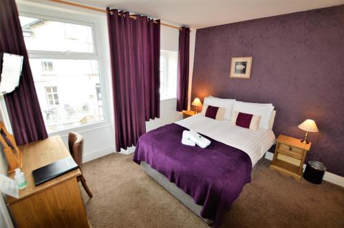 ウィンダミアにあるAll Seasons Restのホテルルーム 紫の毛布付きのベッド1台付