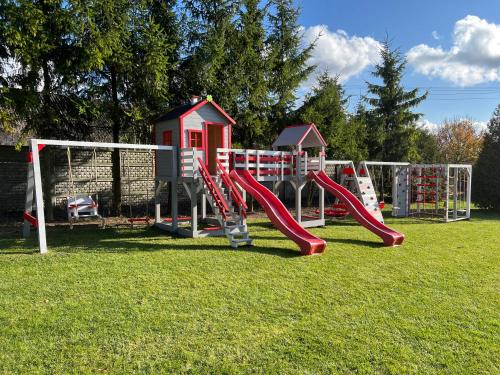 un parque infantil con un tobogán en un campo de césped en Zajazd Gościniec, en Nowosiolki-Kolonia