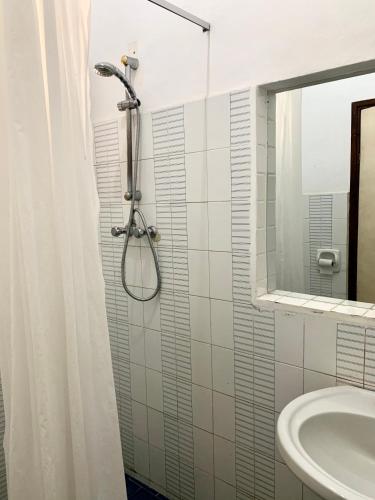 y baño con ducha y lavamanos. en Baobab Village One Bedroom apartment - Type I, en Dar es Salaam