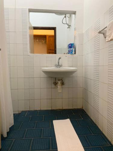 a bathroom with a sink and a mirror at Baobab Village One Bedroom apartment - Type I in Dar es Salaam
