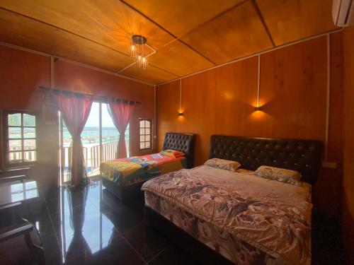 une chambre avec un lit, une table et une fenêtre dans l'établissement Tioman Santai Resort, à l'Île Tioman
