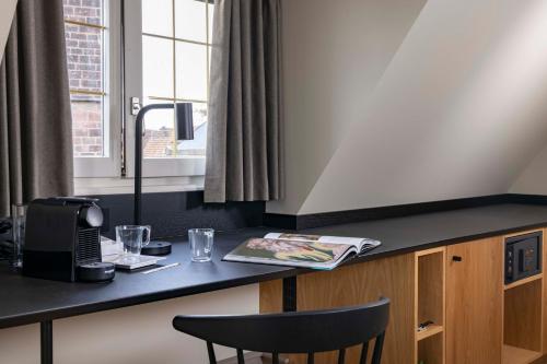 a kitchen with a desk and a chair at Hotel La Diligence in Obernai