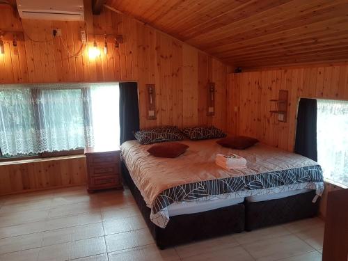 um quarto com uma cama grande num quarto de madeira em Дургунската къща -Durgunskata kashta em Stolat