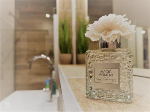 a glass jar with a flower in it on a bathroom counter at FeWo Pönblick in Willingen