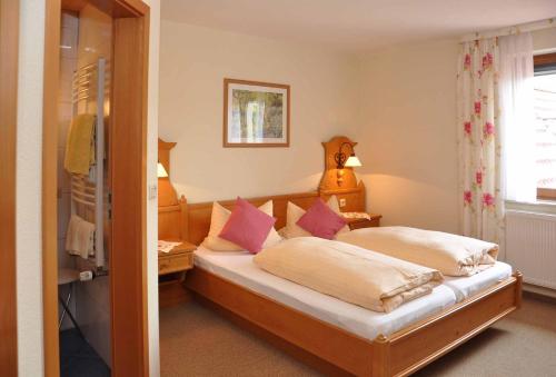 ein Schlafzimmer mit einem Bett mit rosa Kissen in der Unterkunft Landhotel Zur Pferdetränke in Schleid