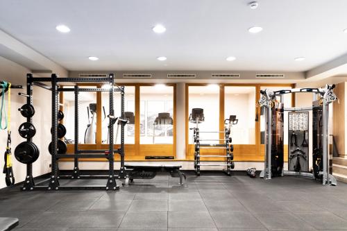 a gym with several treadmills and weights at Hotel & Spa Sonne 4 Sterne Superior in Kirchberg in Tirol