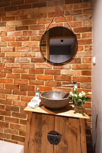 a bathroom with a stone sink and a brick wall at Hotel Mazuria Country & SPA in Mrągowo