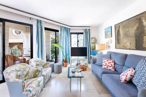a living room with a blue couch and a tv at Ca Na Bel in Port de Soller
