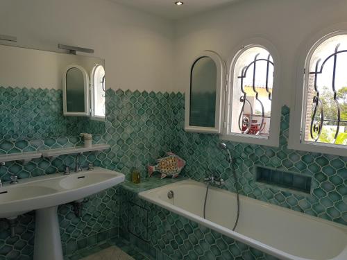 La salle de bains est pourvue d'une baignoire, d'un lavabo et de 2 fenêtres. dans l'établissement VILLA REVA 3 CHAMBRES, aux Issambres