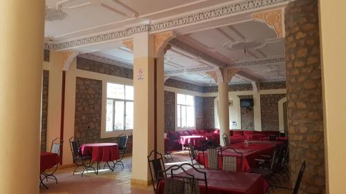 a dining room with red tables and chairs at Auberge Restaurant Fatihi Freres in Tinerhir