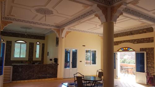 a room with a pillar and a table and chairs at Auberge Restaurant Fatihi Freres in Tinerhir
