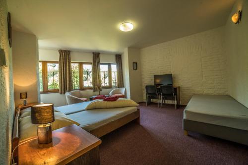 a bedroom with a bed and a couch and a table at Hotel Pivovarská bašta in Vrchlabí