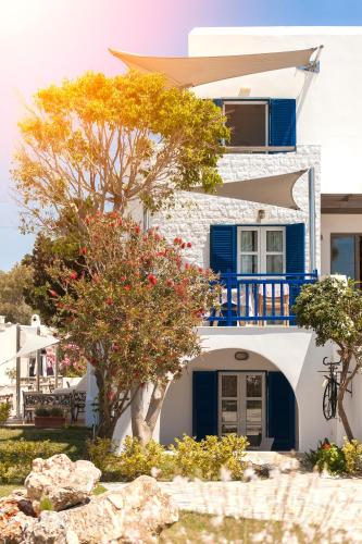 a house with blue and white walls and trees at Athina Studios and Suites Plaka in Plaka