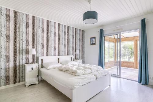 une chambre blanche avec un lit et une fenêtre dans l'établissement Maison avec piscine pour 6 personnes, à Les Sables-dʼOlonne