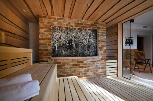 a living room with a brick wall and a fireplace at Hotel Mazuria Country & SPA in Mrągowo