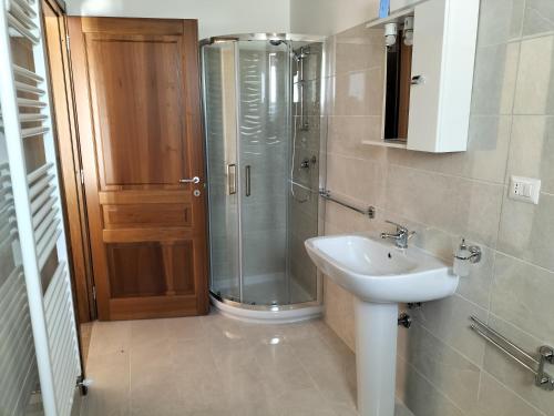 La salle de bains est pourvue d'une douche en verre et d'un lavabo. dans l'établissement Agriturismo Dipinto Dal Sole, à Padula