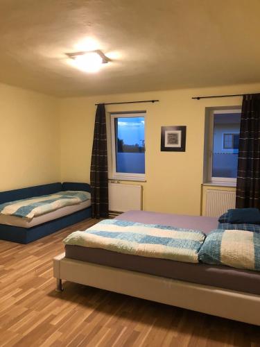 FrauenhofenにあるGemütliche 3 Zimmer Wohnungのベッドが2つと窓が2つある寝室