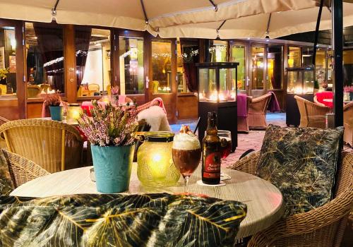a table with a glass of beer and flowers on it at Hotel Schaepkens van St Fijt in Valkenburg