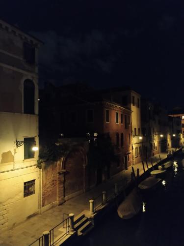 a city street at night with boats in a canal at B&B Cà del Poeta in Venice