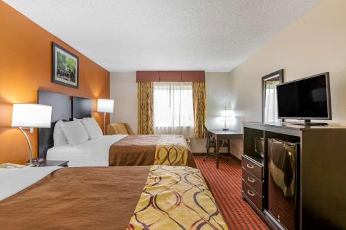 A bed or beds in a room at Rodeway Inn Coopersville