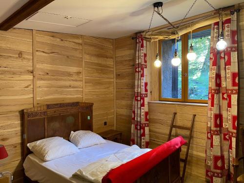 sypialnia z łóżkiem w pokoju z drewnianymi ścianami w obiekcie Grange rénovée, Pyrénées Ariégeoises, Gîte haute Ariège w mieście Auzat