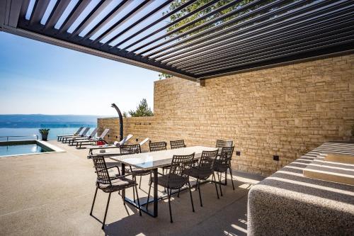 a patio with a table and chairs next to a brick wall at Villa Dispet, sea view, pool, jacuzzi, sauna, cinema in Omiš