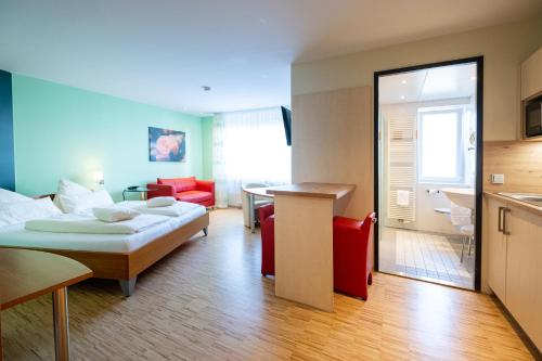 a hotel room with a bed and a kitchen at Hotel Am Froschbächel in Bühl