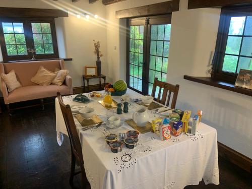 a table with a white table cloth on it at Slerra Hill Bed and Breakfast, Clovelly in Bideford