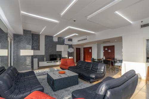 a living room with black leather furniture and a table at Elan Rimal 5 Suites in Dubai
