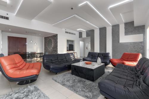 a living room with couches chairs and a table at Elan Rimal 5 Suites in Dubai