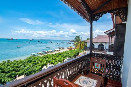 a balcony with a view of the ocean and a beach at Tembo House Hotel in Zanzibar City