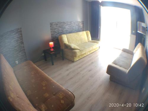 sala de estar con sofá, silla y vela en 2060 Zwycięstwa 5G - Tanie Pokoje w apartamencie - samodzielne zameldowanie - self check in, en Poznan