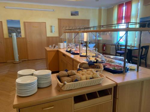 a kitchen with plates and food on a counter at Pension zur Ostsee in Kolpinsee
