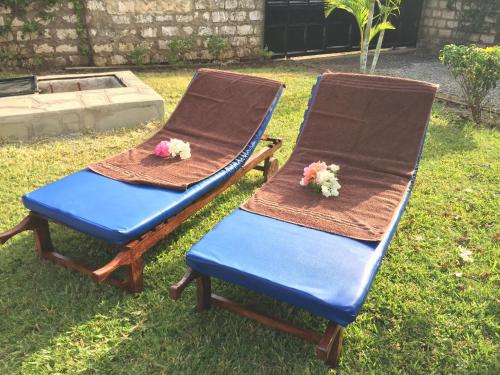 two chairs with flowers on them sitting in a yard at MASKANI Villa in Galu