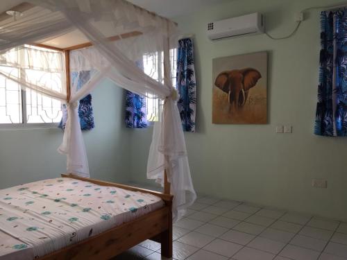 a bedroom with a bed with a canopy at MASKANI Villa in Galu