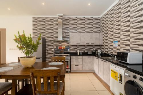 a kitchen with a wooden table with a plant on it at Royale Suites by Arc Royal Luxury Apts in Anse Royale