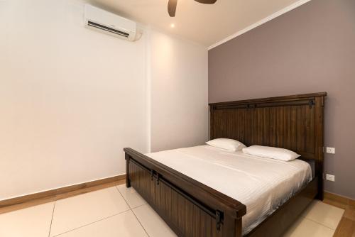 a bedroom with a bed with white sheets and a fan at Royale Suites by Arc Royal Luxury Apts in Anse Royale