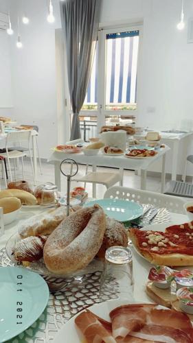 a table filled with different types of bread and food at Maison De luxe in Pompei