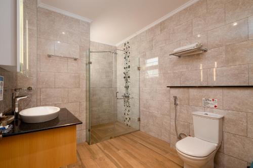 a bathroom with a toilet and a sink and a shower at Royale Suites by Arc Royal Luxury Apts in Anse Royale