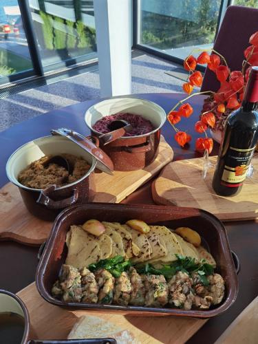 a table with a pan of food and a bottle of wine at Hotel Eurobus in Kaluža