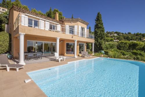 Villa con piscina frente a una casa en Villa Lili Rose en Le Lavandou